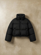 Chaqueta puffer cropped negra de cozyvibe con cuello alto, cierre frontal y diseño acolchado térmico