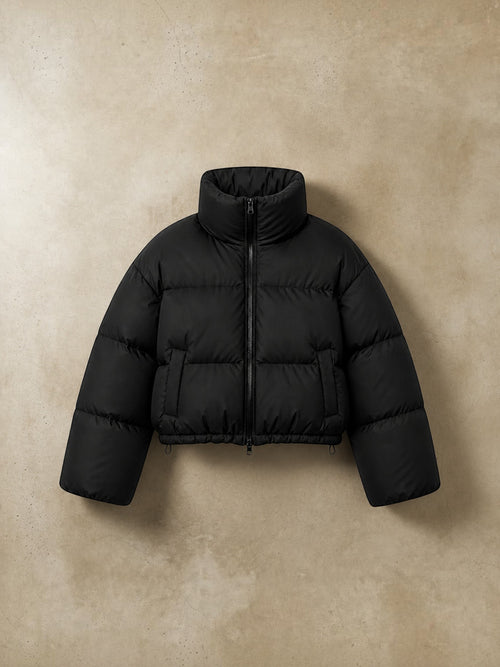 Chaqueta puffer cropped negra de cozyvibe con cuello alto, cierre frontal y diseño acolchado térmico