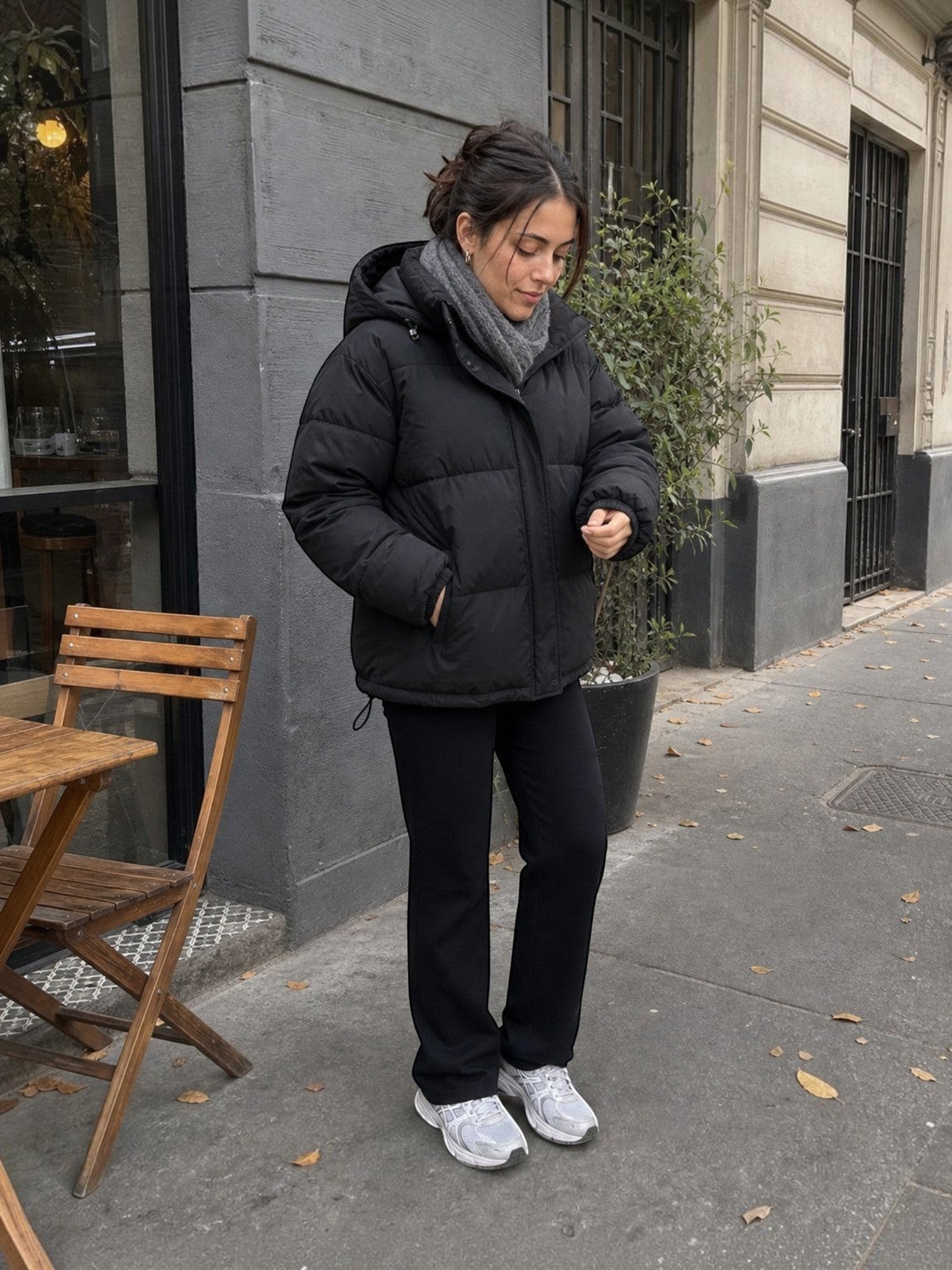 Mujer vistiendo chaqueta puffer negra oversize con capucha de cozyvibe en un entorno urbano