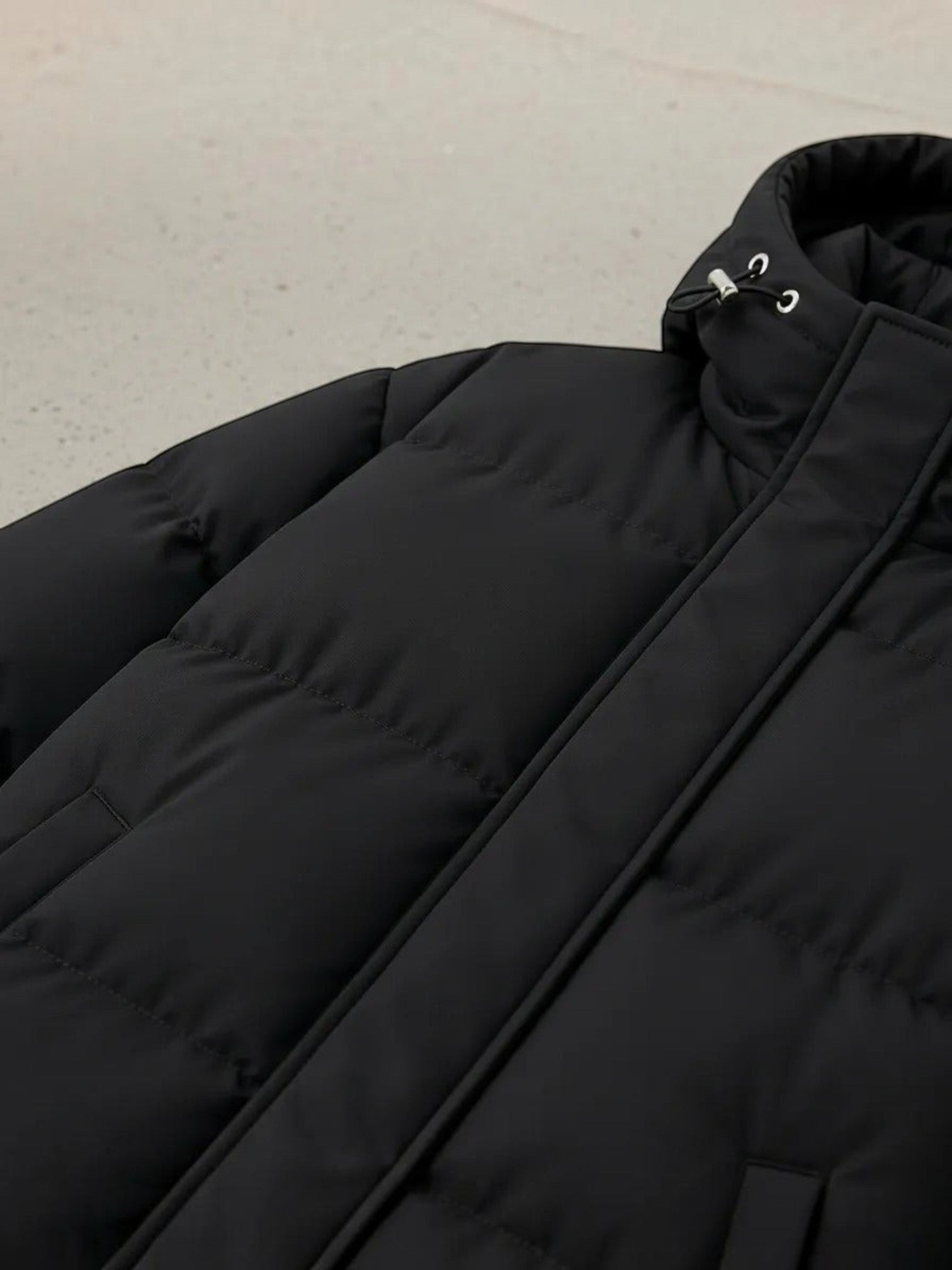 Chaqueta puffer negra unisex de cozyvibe con diseño acolchado, capucha ajustable y cierre frontal de cremallera