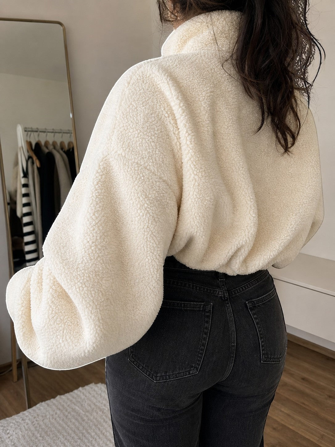 Polerón teddy cozyvibe color albaricoque con cuello alto y ajuste oversize, visto desde atrás sobre jeans negros.