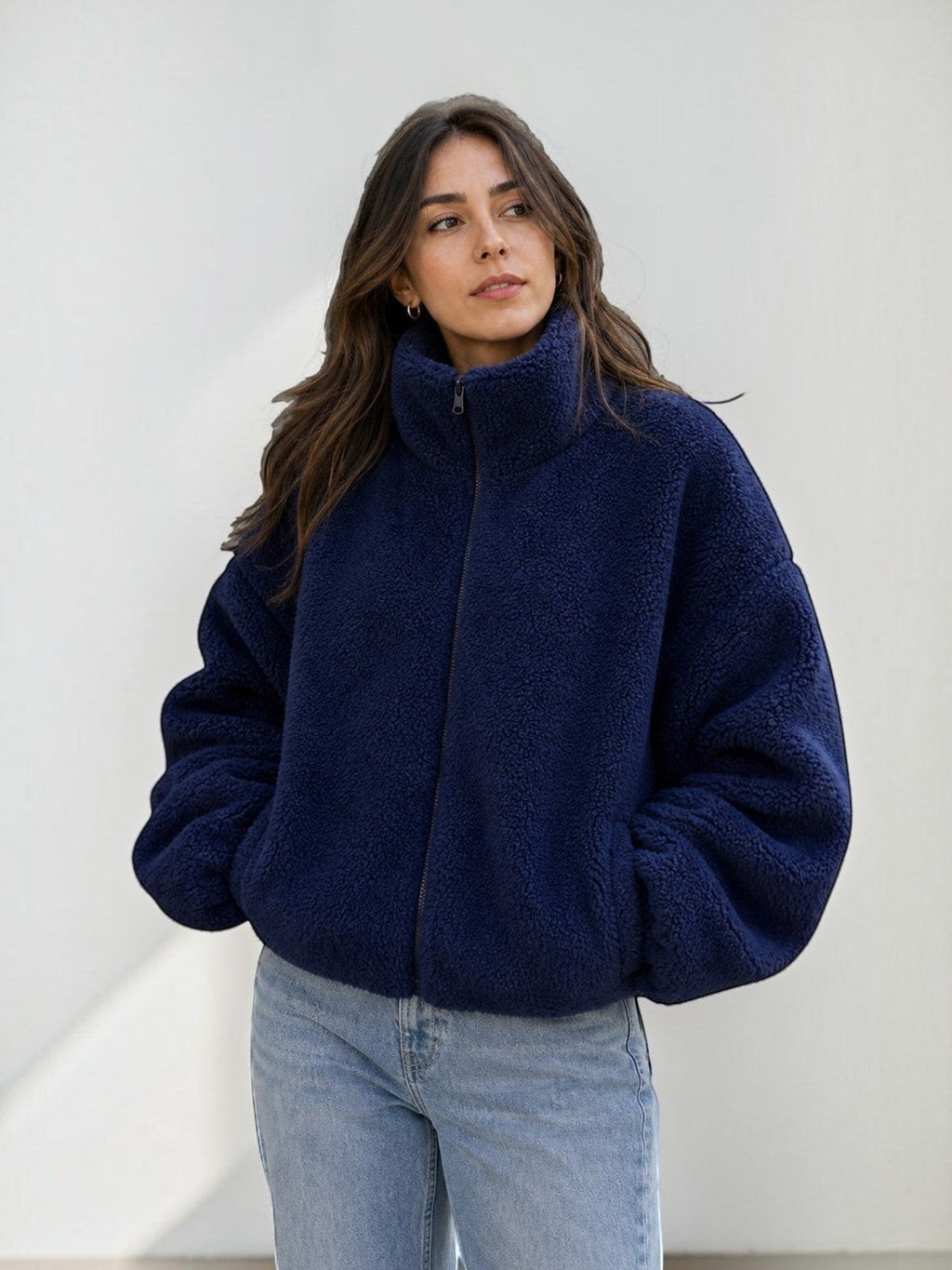 Modelo vistiendo polerón teddy azul marino de cozyvibe con cuello alto, cierre frontal y ajuste oversize