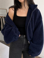 Polerón teddy azul marino cozyvibe de cuello alto con cierre frontal y ajuste oversize sobre top negro y jeans