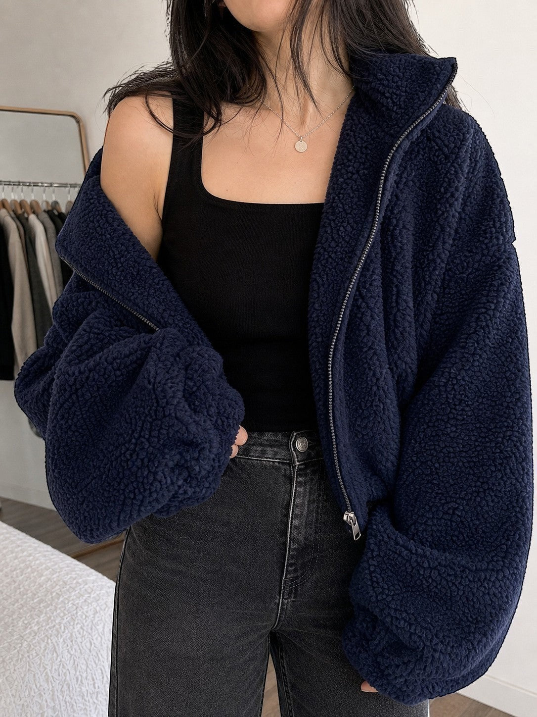 Polerón teddy azul marino cozyvibe de cuello alto con cierre frontal y ajuste oversize sobre top negro y jeans