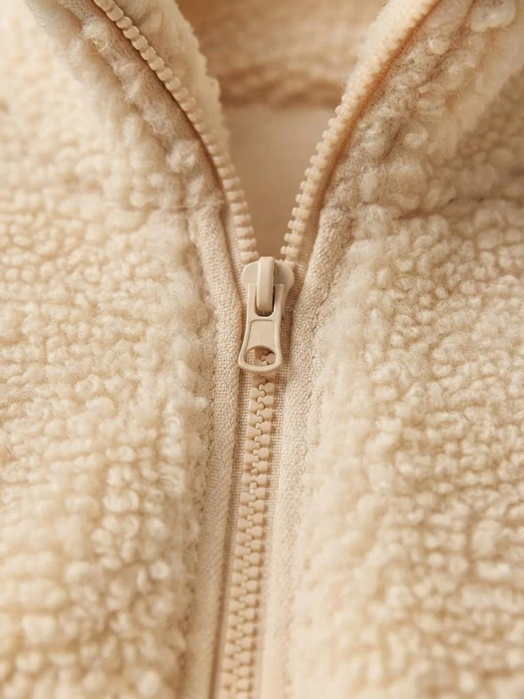 Detalle de cierre frontal en polerón teddy color albaricoque de cozyvibe con textura de terciopelo de cordero