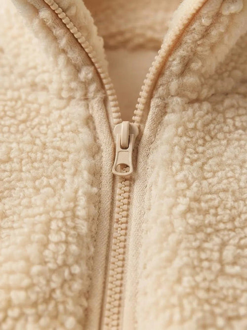 Detalle de cierre frontal en polerón teddy color albaricoque de cozyvibe con textura de terciopelo de cordero
